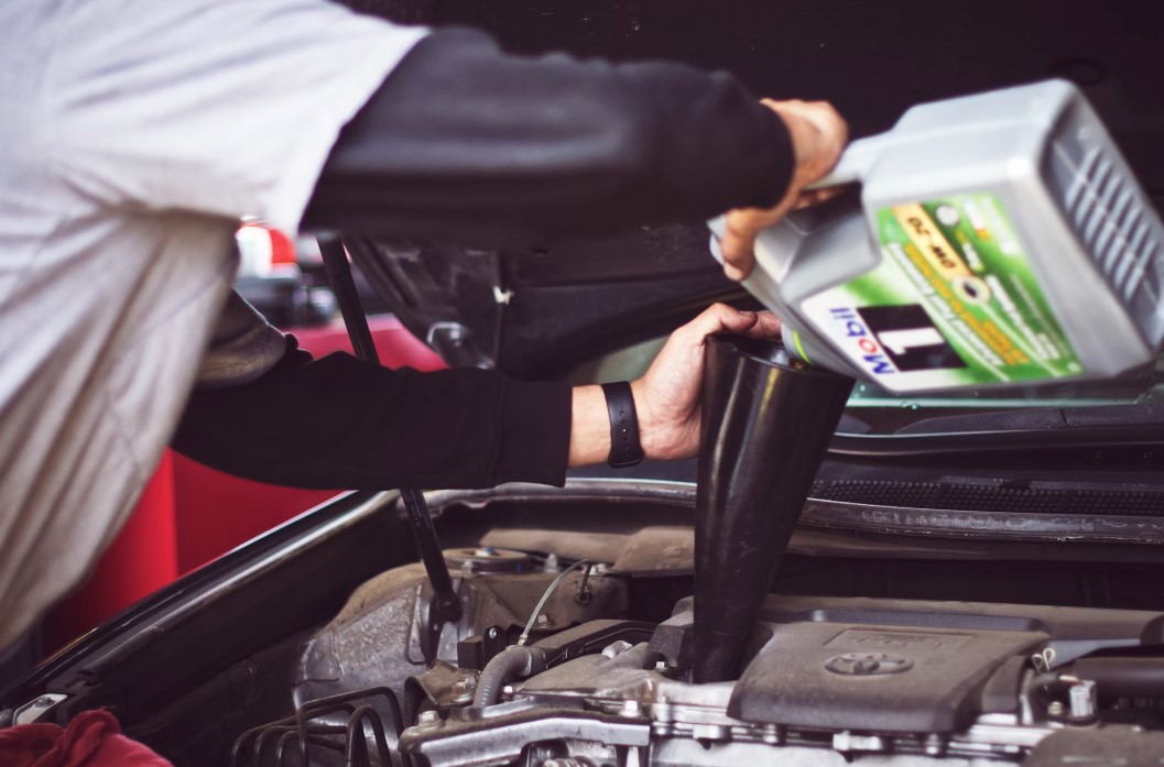 man-refilling-motor-oil-on-car-engine-bay
